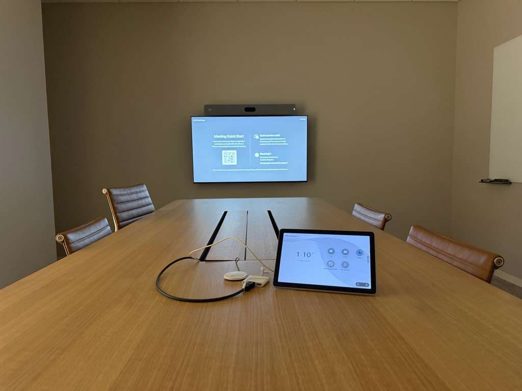 Small meeting room with a display, camera bar and tabletop touch controller for one-touch calls