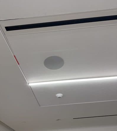 In-ceiling speaker lined up with a linear air diffuser and a strip light