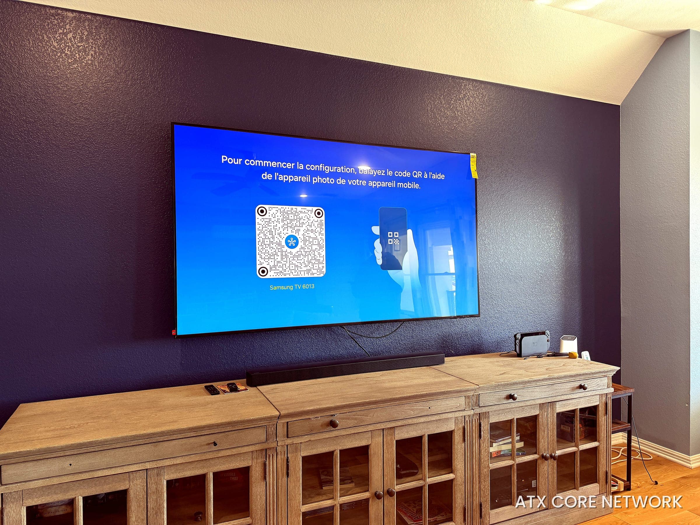 Living room TV and soundbar wall-mounted with concealed wiring on a navy accent wall