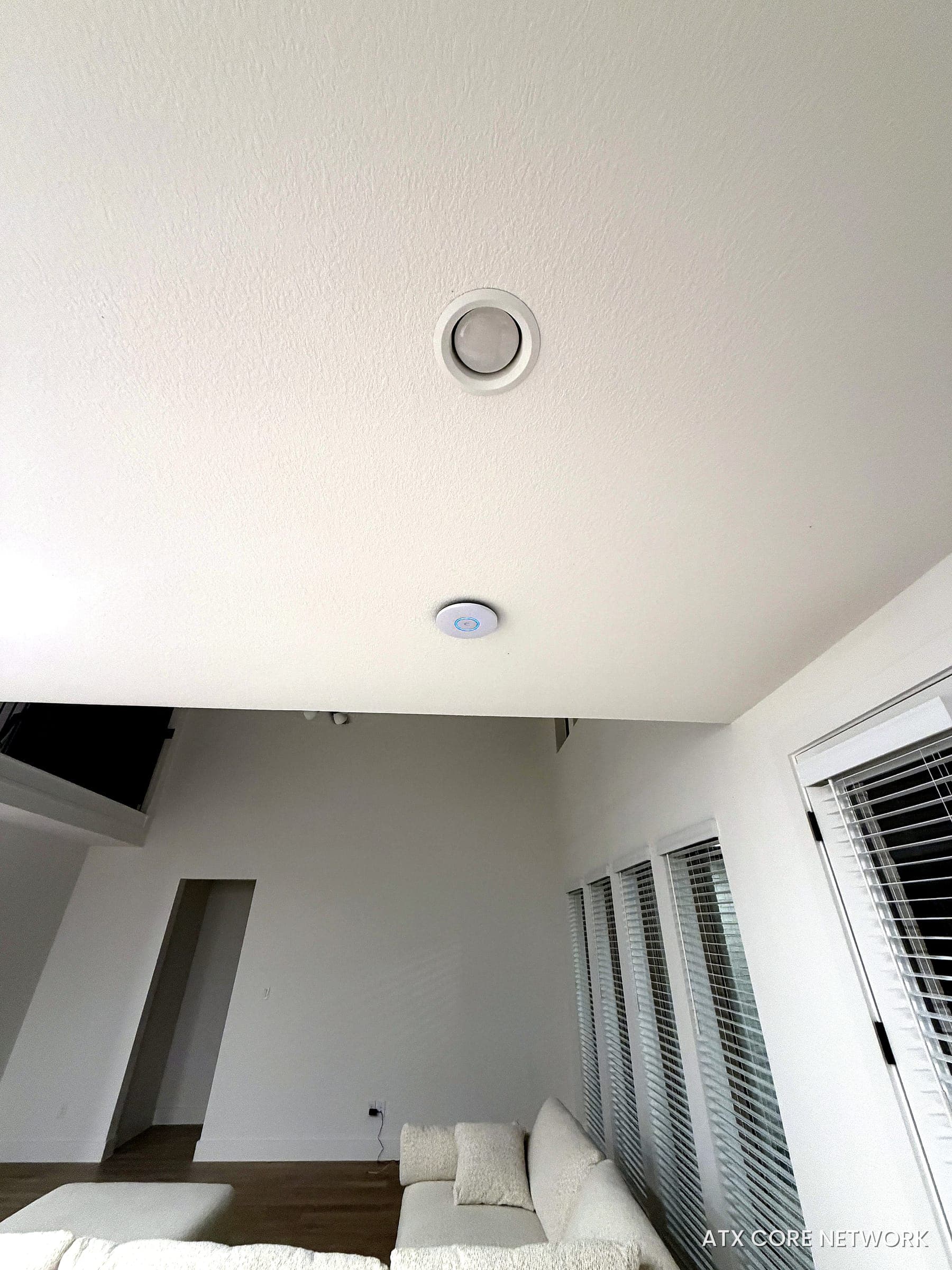 Low-profile Wi-Fi access point blended into the ceiling of a bright Austin living room